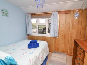 a small bedroom with a bed and a window at Chalet 18 Smarty's View in Aberystwyth