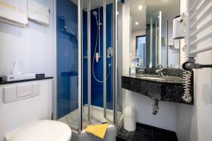 a bathroom with a shower and a toilet and a sink at Hotel Restaurant Esser in Wegberg +27 photos