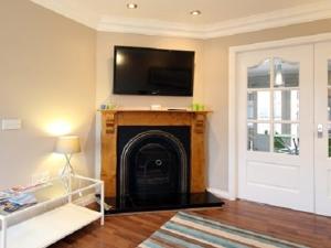 a living room with a fireplace with a flat screen tv at Luxurious KC House in Dungannon
