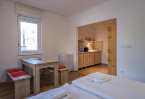 a room with a bed and a desk and a table at Bordoma Falusi Vendégház in Balatonszőlős