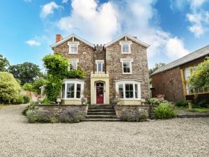 an exterior view of a brick house with a red door at Wheelbarrow Castle in Stoke Prior