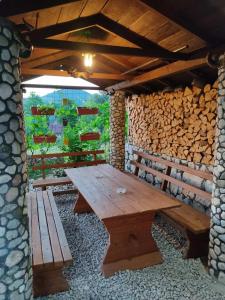 a wooden picnic table and a bench in a shed at Apartman Rakovica in Sarajevo