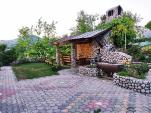 a stone building with a bench in a garden at Apartman Rakovica in Sarajevo +15 photos