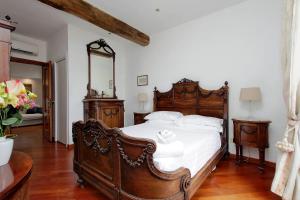 羅馬的住宿－特拉茲納沃納酒店，一间卧室配有一张大木床和镜子