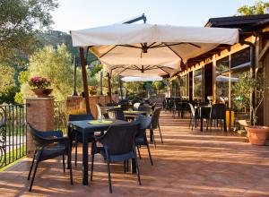 un patio extérieur avec des tables, des chaises et des parasols dans l'établissement Manfredi Agriturismo, à Savuto