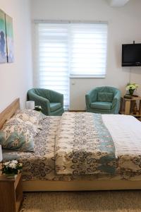 a bedroom with a large bed and two chairs at Modesty Zlatar in Nova Varoš +22 photos