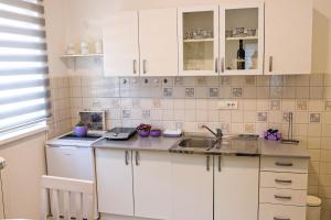 a kitchen with white cabinets and a sink at Modesty Zlatar in Nova Varoš