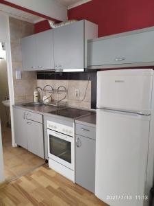 a kitchen with white appliances and red walls at Apartmani KiKi in Utjeha