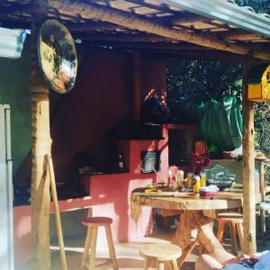 eine Terrasse mit einem Tisch und einigen Holzhockern in der Unterkunft Recanto da Filó Serra do Cipó in Serra do Cipo