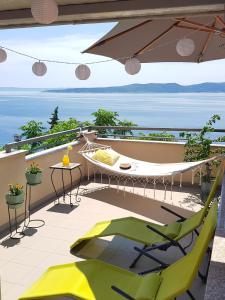 a balcony with a hammock and a view of the ocean at Villa Skalinada with sea view in Brela +18 photos