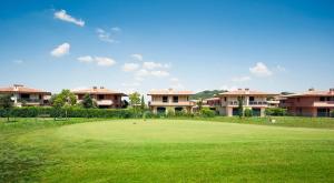 Terre dei Consoli Resort e Golf في Monterosi: إطلالة على ملعب قولف أخضر مع وجود بيوت في الخلف