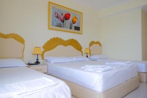 a hotel room with two beds and a painting on the wall at Republika Hotel in Sarandë
