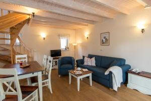 a living room with a blue couch and a table at Family Club Harz in Quedlinburg