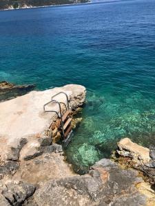 a bench sitting on the edge of a body of water at Villa LeSunLuka Lefkada in Vasiliki