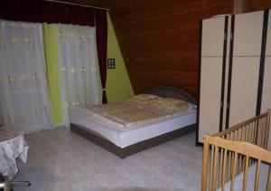 シオーフォクにあるMarika Vendégházのベッドルーム1室(ベッド1台、白いカーテン付)