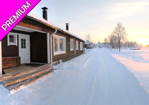 una casa cubierta de nieve junto a una casa en Camping Nilimella, en Sodankylä