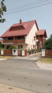 een huis met een rood dak op een straat bij Katalin apartman in Balatonkeresztúr