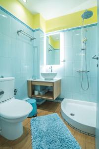 a bathroom with a tub and a toilet and a sink at Saronis Hotel Agistri - Adults Only in Skala