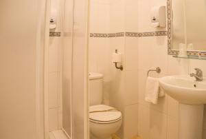 y baño con aseo y lavamanos. en Hostal Patio Andaluz, en Punta Umbría
