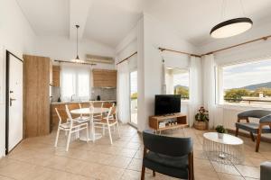 a living room with a table and chairs and a television at Cove Suites Apartment in Iraklitsa
