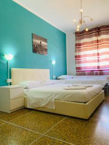 1 dormitorio con 1 cama grande y paredes azules en Pearl Pisa guest house, en Pisa