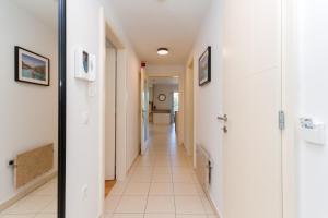 a hallway with white walls and a white tile floor at Premium Marina Apartments with Sea View by Locap Group in Portorož