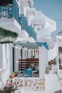 a row of white buildings with blue balconies at Saronis Hotel Agistri - Adults Only in Skala