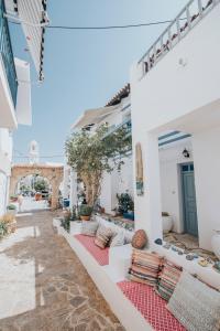 a patio with white walls and red cushions at Saronis Hotel Agistri - Adults Only in Skala