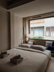 a bedroom with a large bed with two towels on it at NORN Nimman13 Boutique Hotel Chiang Mai in Chiang Mai +34 photos