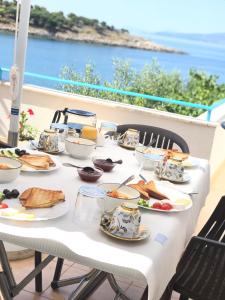 Sea Breeze Villa في سارنده: طاولة بيضاء عليها صحون طعام