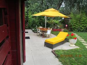 a patio with a table and a yellow umbrella at Locatlantique in Aytré