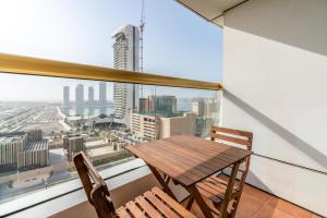 a table and chairs in a room with a large window at Lux BnB Elite Residence Harbor Views in Dubai