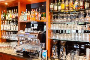 a bar with a lot of alcohol bottles and glasses at Altora Eisenbahn Themenhotel in Wernigerode