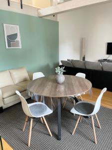Charming Central Apartments في بادن بادن: طاولة وكراسي في غرفة معيشة مع أريكة