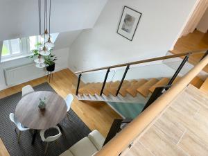 a living room with a table and a staircase at Charming Central Apartments in Baden-Baden