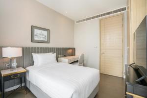 Postel nebo postele na pokoji v ubytování Magnolias Ratchadamri Boulevard Serviced Residences