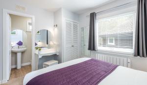 a white bathroom with a white bed and white walls at High Range Self-Catering Chalets in Aviemore