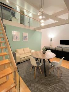 Charming Central Apartments في بادن بادن: غرفة معيشة مع طاولة وكراسي وأريكة