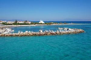 uma pequena ilha na água com um grupo de barcos em Saronis Hotel Agistri - Adults Only em Skala