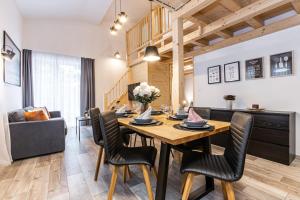 a dining room and living room with a table and chairs at KORZO Lipno in Lipno nad Vltavou