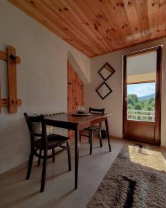 a dining room with a table and chairs and a window at Apartment Winter Star in Kolašin