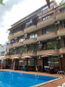 a hotel with a swimming pool in front of a building at Park and pool family room in Nesebar