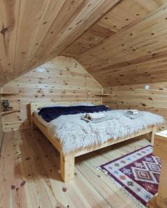 a bed in a wooden room in a log cabin at Apartment Winter Star in Kolašin