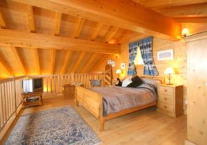 een slaapkamer met een bed in een blokhut bij Chalet Forget me not in Gryon