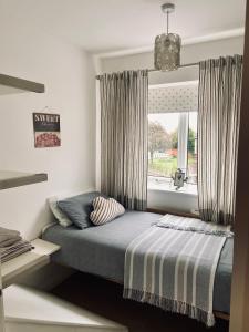 a bedroom with a bed and a window with curtains at Lavender House in Edwinstowe