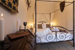 a bedroom with a metal canopy bed and a table at Le Secret de la Taverne - Netflix/Wifi - Chasse Aux Trésor à l'intérieur in Carcassonne