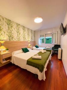 a hotel room with two beds and a desk at PENSIÓN AUGAS QUENTES in Caldas de Reis