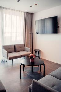 ein Wohnzimmer mit einem Sofa und einem Tisch in der Unterkunft Casino Hotel in Koksijde