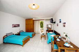 a living room with two beds and a table at Maria Studios & Apartments in Kremasti