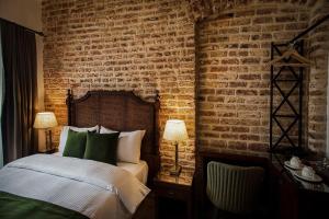 a bedroom with a bed and a brick wall at Mest Hotel Istanbul Sirkeci in Istanbul